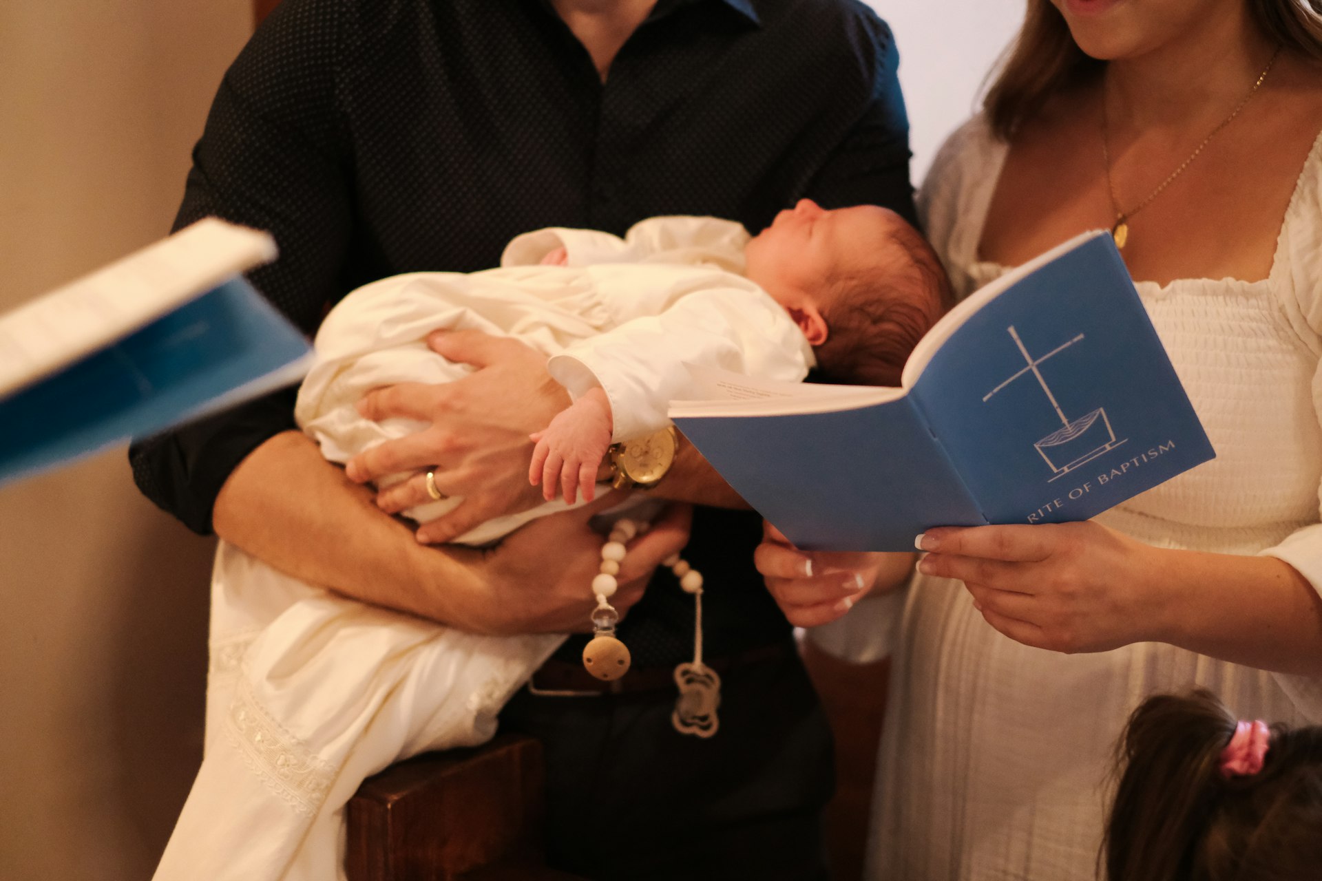 A man holding a baby while reading a book